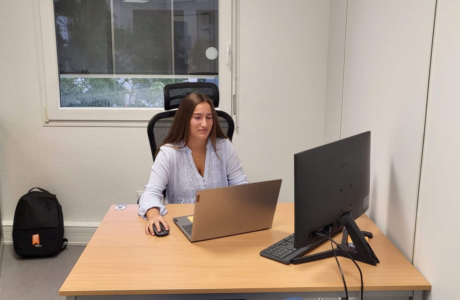 Photo de Lisa VUIBERT dans un bureau, en train de travailler sur son ordinateur portable