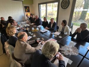 Photo plan large d'une salle de réunion avec tous les cadres de FORMAPI, SELFORME et du GIFOD autour de la table pour un séminaire